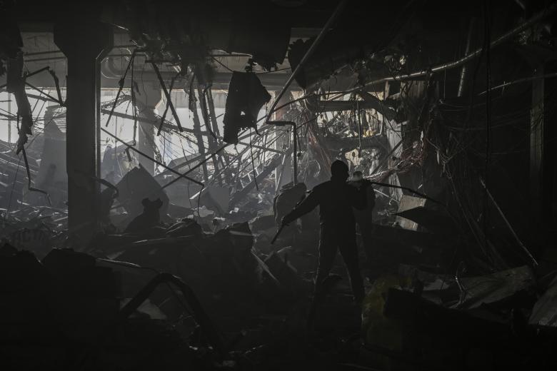 Un militar ucraniano camina entre los escombros dentro del centro comercial Retroville después de un ataque ruso en el noroeste de la capital, Kiev
