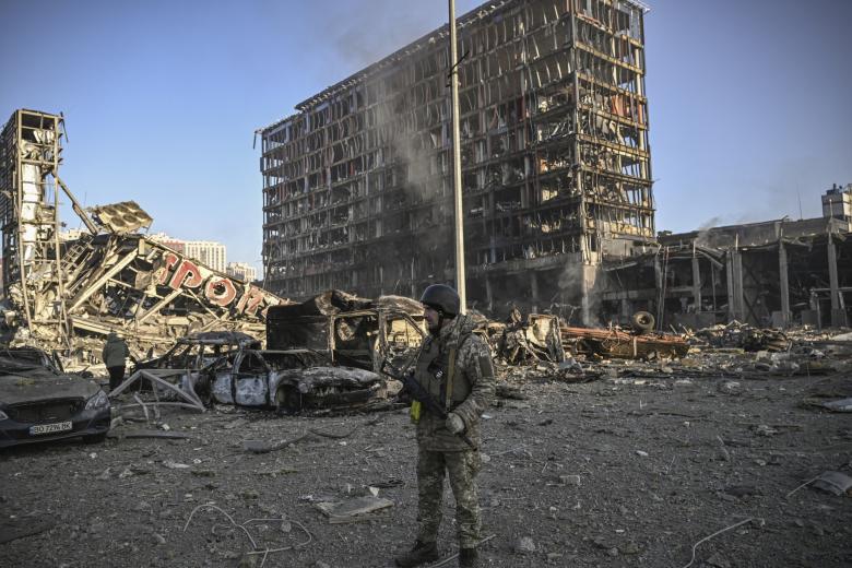 Un militar ucraniano vigila el perímetro del centro comercial Retroville de Kiev, arrasado este domingo durante un bombardeo ruso