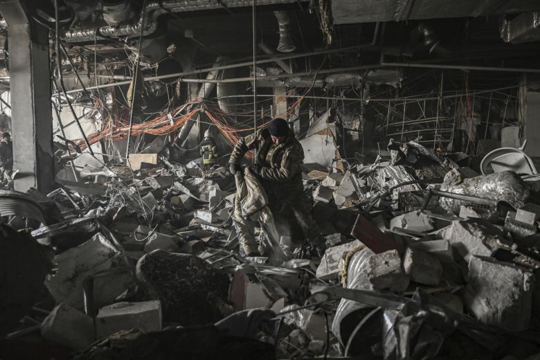 Militares ucranianos buscan entre los escombros dentro del centro comercial Retroville después de un ataque ruso en el noroeste de Kiev