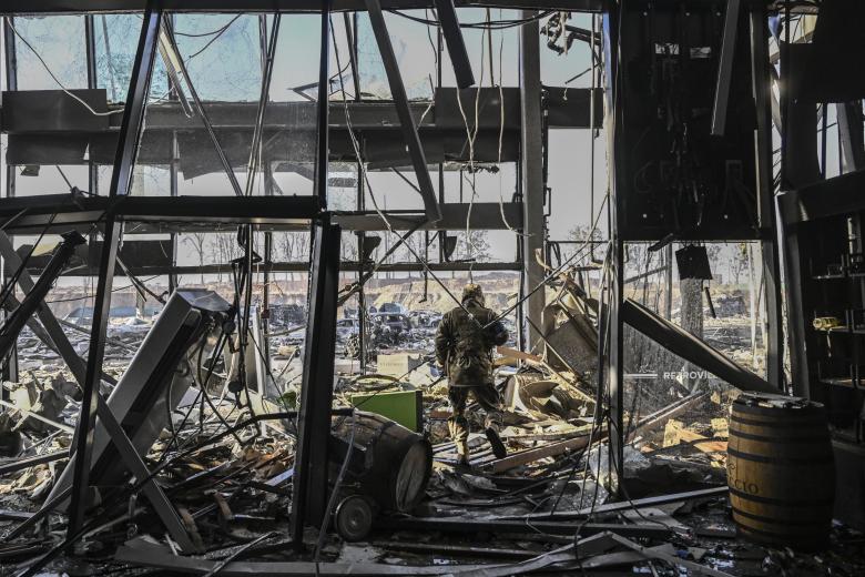 Un militar ucraniano camina entre escombros dentro del centro comercial Retroville arrasado
