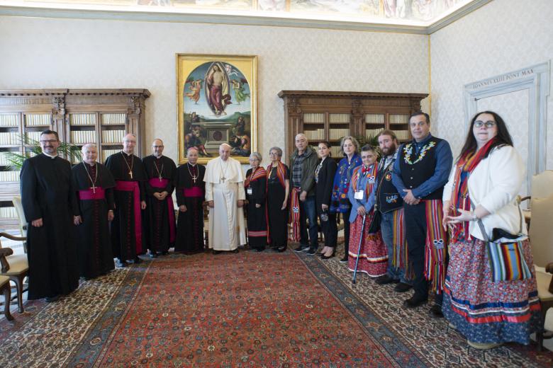 This photo taken and handout on March 28, 2022 by The Vatican Media shows Pope Francis (C) posing with Canada's Metis National Council President, Cassidy Caron (6thR), Interim President of the Fraser Valley Metis Association (FVMA), Pixie Wells (4thR), president of the Canadian Conference of Catholic Bishops (CCCB) Raymond Poisson (5thL) and delegation members in The Vatican, as part of a series of a week-long meetings of Canada's Indigenous elders, leaders, survivors and youth at the Vatican. (Photo by Handout / VATICAN MEDIA / AFP) / RESTRICTED TO EDITORIAL USE - MANDATORY CREDIT "AFP PHOTO / VATICAN MEDIA" - NO MARKETING - NO ADVERTISING CAMPAIGNS - DISTRIBUTED AS A SERVICE TO CLIENTS