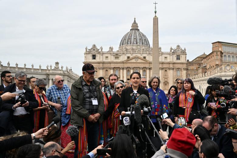 Canada's Metis National Council President, Cassidy Caron (C-R with embroidered jacket), escorted by delegations members, addresses the media on March 28, 2022 at St. Peter's square in The Vatican, following a meeting with the Pope, as part of a series of a week-long meetings of Canada's Indigenous elders, leaders, survivors and youth at the Vatican. (Photo by Andreas SOLARO / AFP)