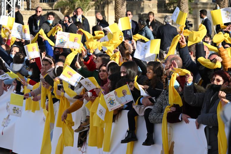 Fieles con banderas vaticanas esperan la llegada del Papa Francisco