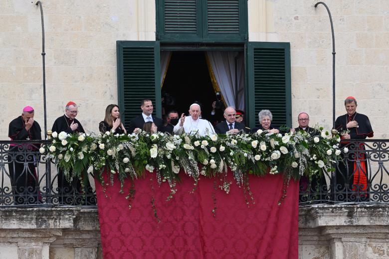 El Papa Franciso saluda desde un balcón rodeado de las autoridades maltesas y vaticanas