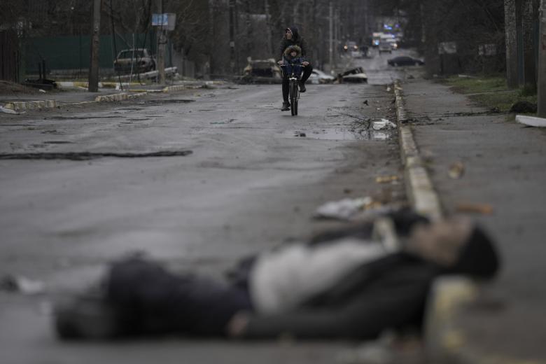 EDITORS NOTE: Graphic content / Bodies lie on a street in Bucha, northwest of Kyiv, as Ukraine says Russian forces are making a "rapid retreat" from northern areas around Kyiv and the city of Chernigiv, on April 2, 2022. - The bodies of at least 20 men in civilian clothes were found lying in a single street Saturday after Ukrainian forces retook the town of Bucha near Kyiv from Russian troops, AFP journalists said. Russian forces withdrew from several towns near Kyiv in recent days after Moscow's bid to encircle the capital failed, with Ukraine declaring that Bucha had been "liberated". (Photo by RONALDO SCHEMIDT / AFP)