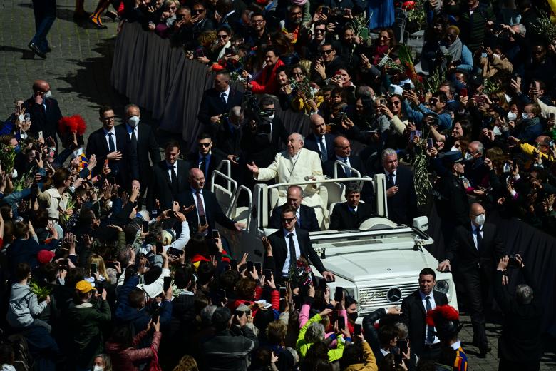 Pope Francis (C) leaves at the end of the Palm Sunday mass in St. Peter square, at the Vatican on April 10, 2022. - Palm Sunday is the final Sunday of Lent, the beginning of the Holy Week, and commemorates the triumphant arrival of Jesus Christ in Jerusalem, days before he was crucified. (Photo by Vincenzo PINTO / AFP)