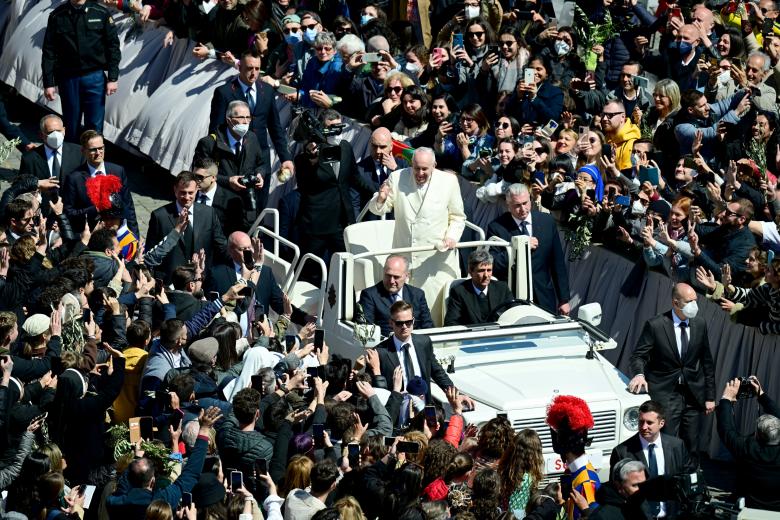 Pope Francis (C) waves to faitfuls at the end of the Palm Sunday mass in St. Peter square, at the Vatican on April 10, 2022. - Palm Sunday is the final Sunday of Lent, the beginning of the Holy Week, and commemorates the triumphant arrival of Jesus Christ in Jerusalem, days before he was crucified. (Photo by Vincenzo PINTO / AFP)