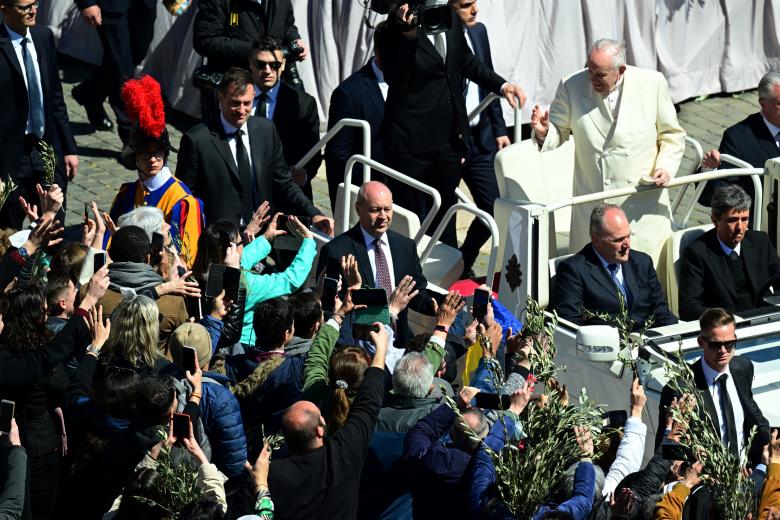 Pope Francis waves to faitfuls at the end of the Palm Sunday mass in St. Peter square, at the Vatican on April 10, 2022. - Palm Sunday is the final Sunday of Lent, the beginning of the Holy Week, and commemorates the triumphant arrival of Jesus Christ in Jerusalem, days before he was crucified. (Photo by Vincenzo PINTO / AFP)