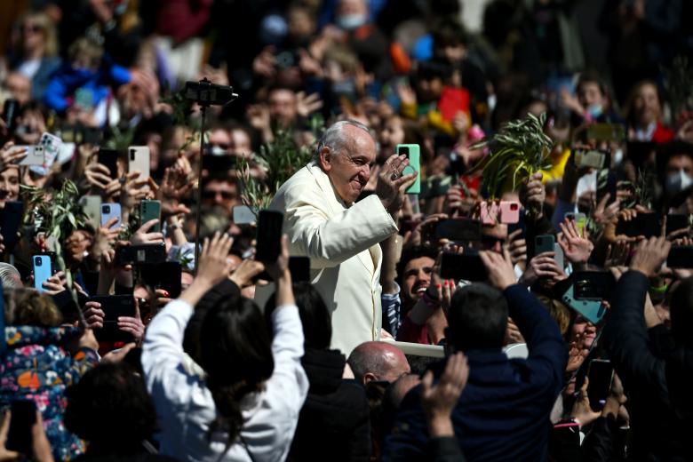 Pope Francis waves to faitfuls at the end of the Palm Sunday mass in St. Peter square, at the Vatican on April 10, 2022. - Palm Sunday is the final Sunday of Lent, the beginning of the Holy Week, and commemorates the triumphant arrival of Jesus Christ in Jerusalem, days before he was crucified. (Photo by Vincenzo PINTO / AFP)
