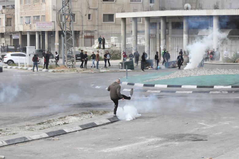 Un palestino patea una granada de gas lacrimogeno durante un enfrentamiento con las tropas israelíes en la ciudad cisjordana de Nablus, Palestina este miércoles