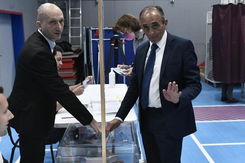 El presidente del partido 'Reconquista' y excandidato presidencial Eric Zemmour (D) emite su voto en un colegio electoral en París