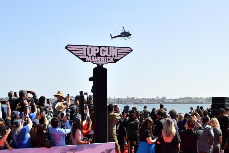 Los asistentes al estreno de Top Gun observan cómo llega el helicóptero que traslada a Tom Cruise al evento, que contó con acrobacias aéreas y mucha presencia de medios