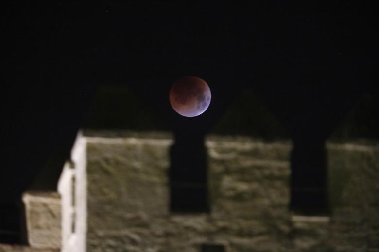 Vista de la Luna sobre las almenas de la torre de la Calahorra, en la ciudad de Córdoba, durante el eclipse total registrado durante la madrugada de este lunes.