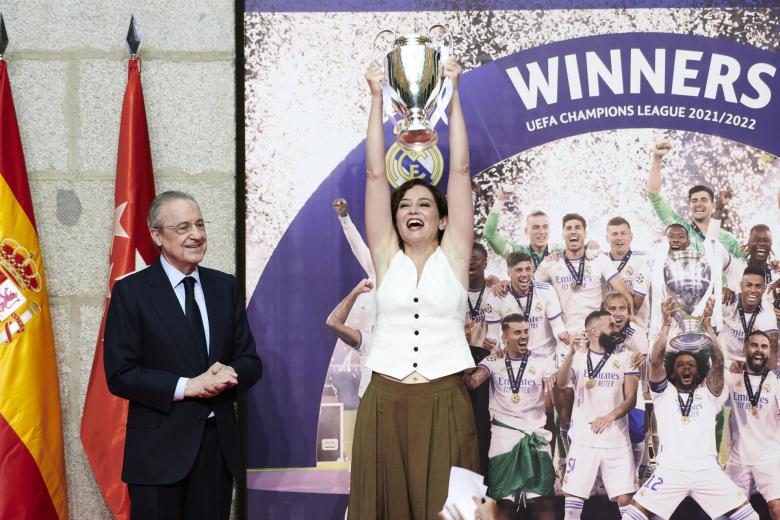 Isabel Díaz Ayuso levanta una pequeña réplica de la Liga de Campeones