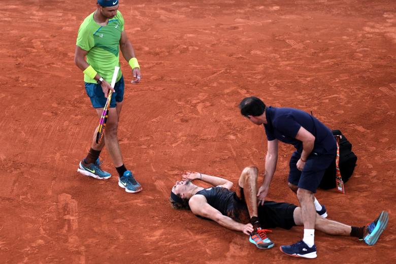 Alexander Zverev en el momento de su lesión. Rafa Nadal se acercó a saludar al alemán en este momento tan duro