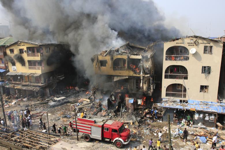 A fire truck passes a warehouse on fire on Lagos Island in Lagos, Nigeria, on Wednesday, Dec. 26, 2012.