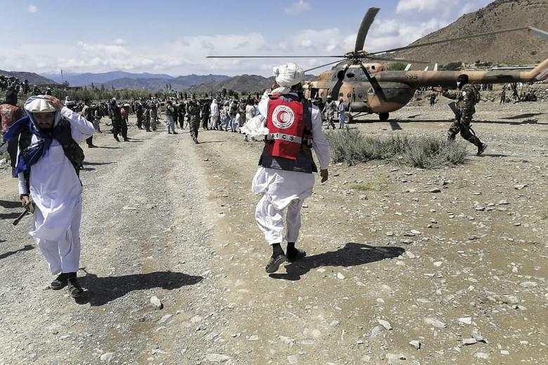 This photograph taken on June 22, 2022 and received as a courtesy of the Afghan government-run Bakhtar News Agency shows soldiers and Afghan Red Crescent Society officials near a helicopter at an earthquake hit area in Afghanistan's Gayan district, Paktika province. - A powerful earthquake struck a remote border region of Afghanistan overnight killing at least 920 people and injuring hundreds more, officials said on June 22, with the toll expected to rise as rescuers dig through collapsed dwellings. (Photo by Bakhtar News Agency / AFP) / XGTY / EDITORS NOTE --- RESTRICTED TO EDITORIAL USE - MANDATORY CREDIT "AFP PHOTO /Bakhtar News Agency " - NO MARKETING - NO ADVERTISING CAMPAIGNS - DISTRIBUTED AS A SERVICE TO CLIENTS - NO ARCHIVE