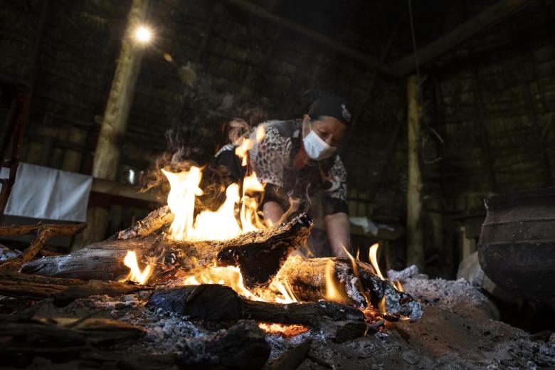 Norma Huentén, cocinera tradicional mapuche, es vista mientras cocina al interior de una ruca, la vivienda tradicional mapuche, que utiliza como parte de su restaurante, Gastronomía Mapuche Millaray, en los alrededores de Puerto Saavedra, el 20 de junio de 2022 en la Araucanía (Chile)