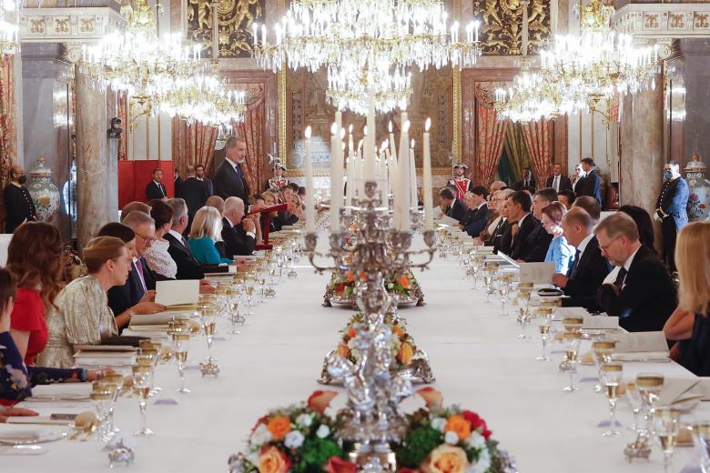El rey Felipe (i-fondo de pie) pronuncia unas palabras en el Comedor de Gala del Palacio Real, durante la cena que los monarcas españoles ofrecen a los jefes de Estado y jefes de Gobierno que participan en la cumbre de la OTAN