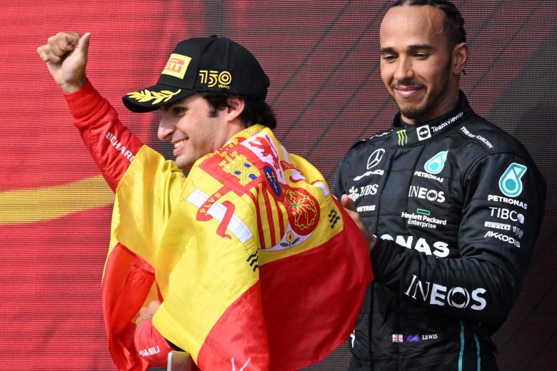 Carlos Sainz, con la bandera de España, al lado de Hamilton, que quedó tercero