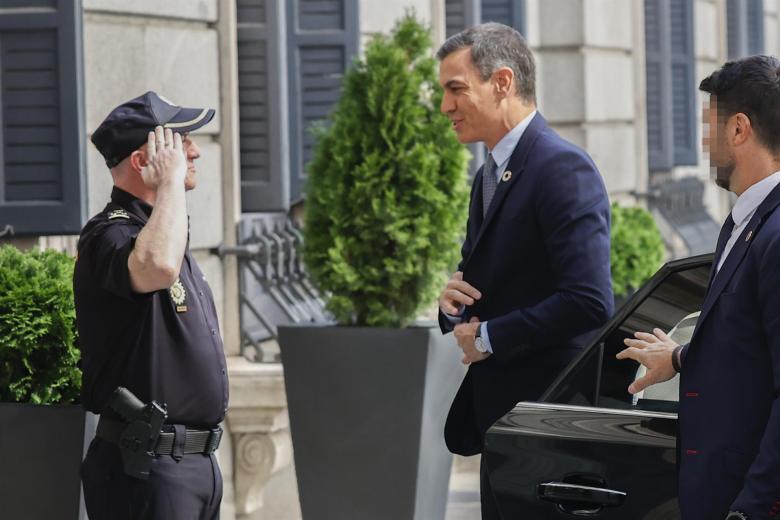 El presidente del Gobierno, Pedro Sánchez (c), a su llegada al Congreso es saludado por un policía nacional