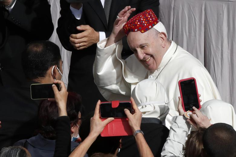 Pope Francis attendee placed a hat on his head in the St. Damaso Courtyard at the Vatican for his weekly general audience, Wednesday, May 12, 2021.  *** Local Caption *** .