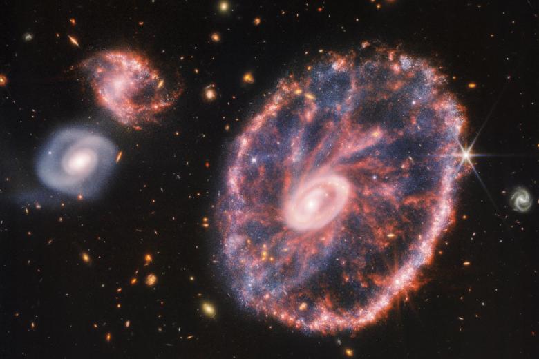 A principios de la semana pasada, la potente mirada infrarroja del telescopio James Webb logró una detallada instantáneo de Rueda de Carro, pero también de dos galaxias compañeras más pequeñas con un telón de fondo de muchas otras galaxias