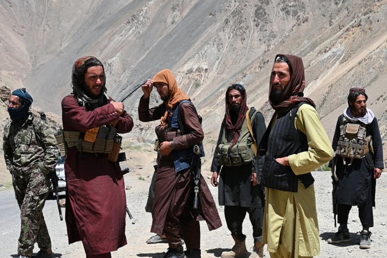 (FILES) This photo taken on July 8, 2022 shows Taliban fighters standing along a road in Paryan district of Panjshir province. - A year since returning to power in Afghanistan, the Taliban are a stronger military force than ever, but threats to their rule do exist. To tighten their grip, the Taliban have poured thousands of fighters into the Panshjir Valley, home to the only conventional military threat the Islamists have faced since their takeover. (Photo by Wakil KOHSAR / AFP)