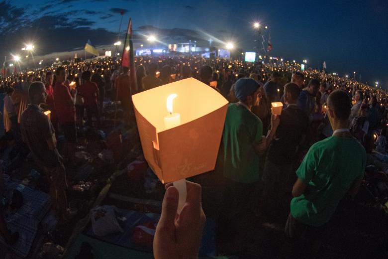 Pilgrims participating in the World Youth Day 2016 hold lit candles as they pray during the evening vigil with PopeFrancis at the Campus Misericordiae in Brzegi, Poland, 30 July 2016.