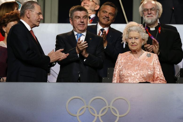 The President of the International Olympic Committee Jacques Rogge, left, and Britain's Archbishop of Canterbury Rowan Williams, back right, applaud as Britain's Queen Elizabeth II, foreground right, arrives during the Opening Ceremony at the 2012 Summer Olympics, Friday, July 27, 2012, in London.