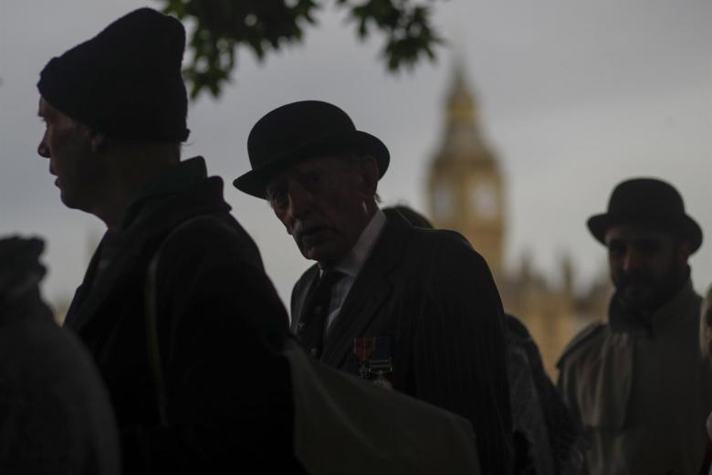 Británicos vestidos con bombín y el Parlamento inglés de fondo