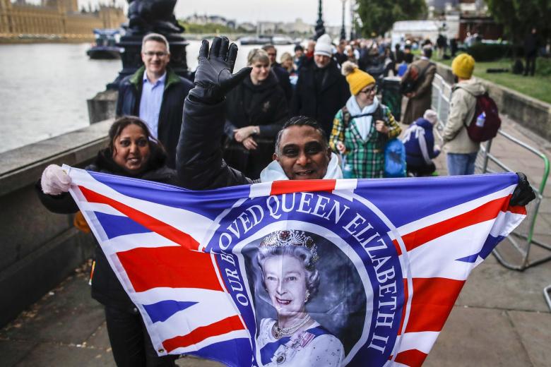 Banderas conmemorativas de la Reina Isabel II en la cola para entrar a la capilla ardiente en Westminster