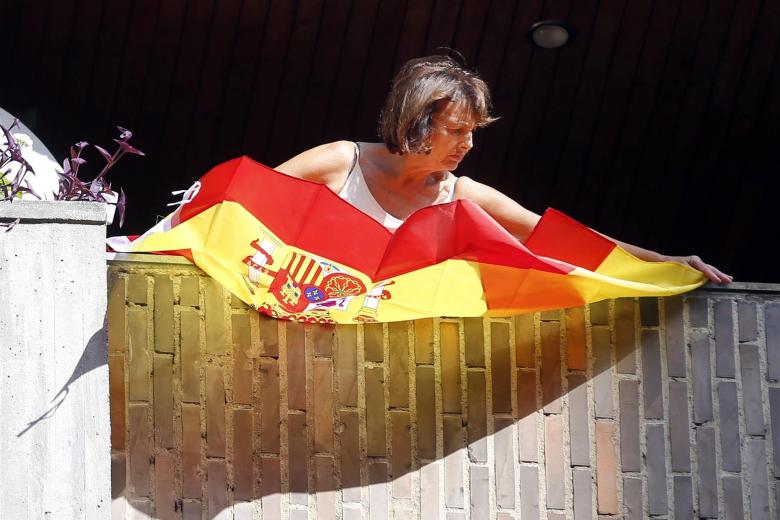 Una mujer despliega una bandera de España
