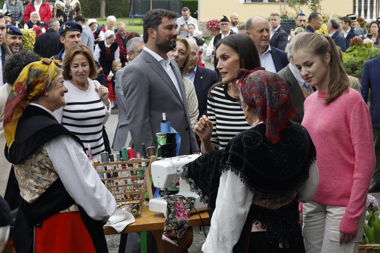 La Reina Letizia y la Princesa de Asturias Leonor conversa con dos mujeres durante la visita de los miembros de la familia real a la parroquia de Cadavedo