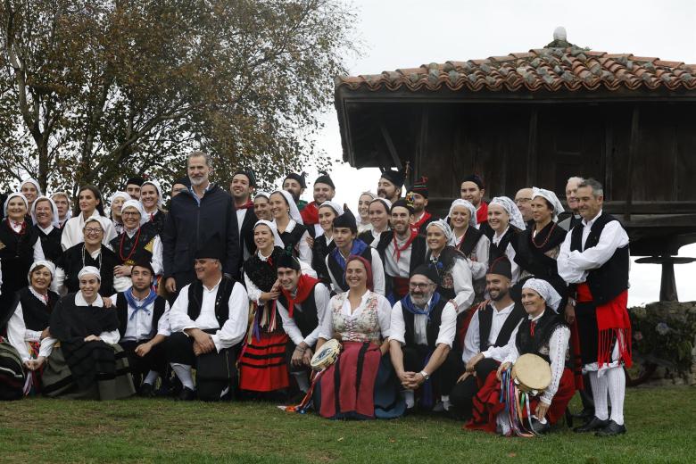 El Rey Felipe VI posa para una foto de grupo junto a un grupo de baile regional en Cadavedo