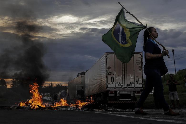Una mujer sostiene una bandera de Brasil durante bloqueo de camioneros