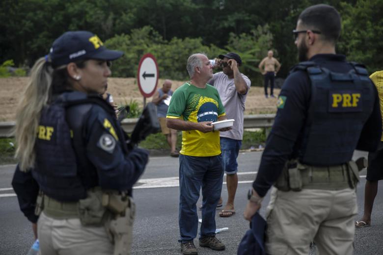 Agentes de la policía federal de Brasil observan el bloqueo de camioneros, en la carretera Presidente Dutra, cerca a Volta Redonda