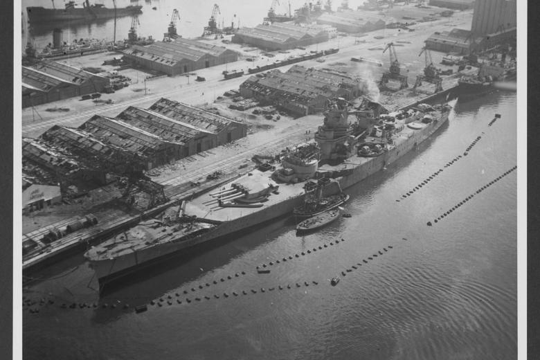 Una vista aérea de estribor del acorazado francés FS Jean Bart (1940) dañado, atado a un muelle en Casablanca, Marruecos, luego de los ataques aéreos de la Flota de EE. UU. en noviembre y diciembre de 1942