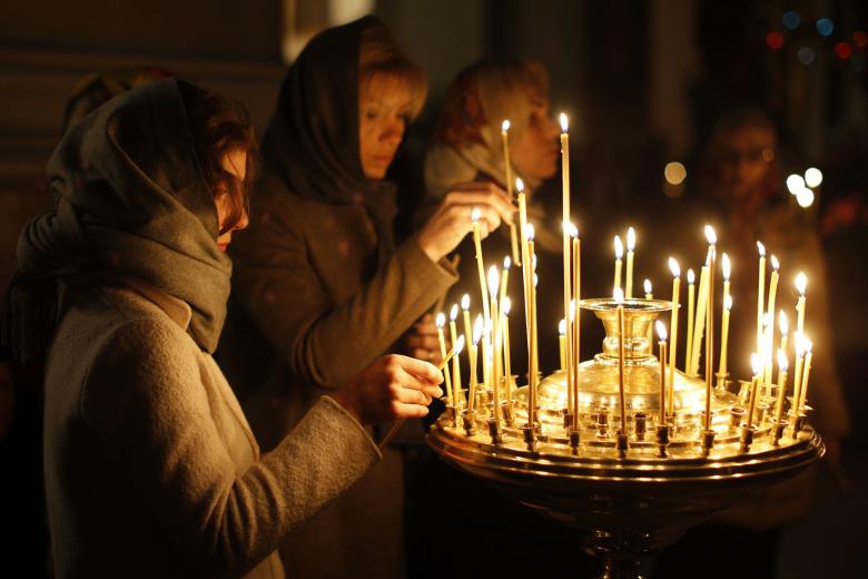 Lithuanian Orthodox believers light candles during an Easter vigil mass in the Prechistensky, the Cathedral Palace in Vilnius, Lithuania, Saturday, April 11, 2015. (AP  Photo/Mindaugas Kulbis)