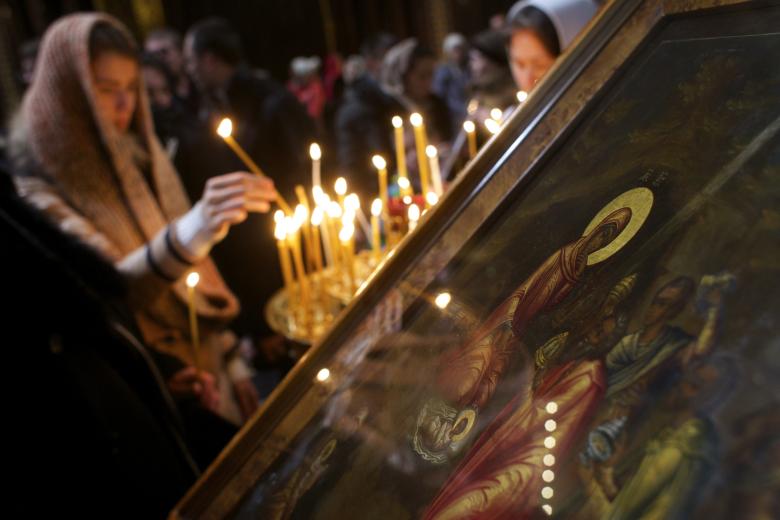 Russian Orthodox believers light candles before the Christmas Mass in the Christ the Savior Cathedral in Moscow, Russia, on Wednesday, Jan. 6, 2016.