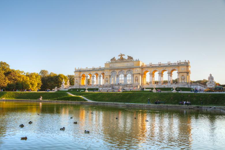 VIENNA - OCTOBER 06: Gloriette Schonbrunn at sunset with tourists on October 06, 2012 in Vienna. It's the largest and most well-known gloriette in Vienna built in 1775 as the last building constructed in the garden according to the plans of Austrian imperial architect Johann Ferdinand Hetzendorf.
