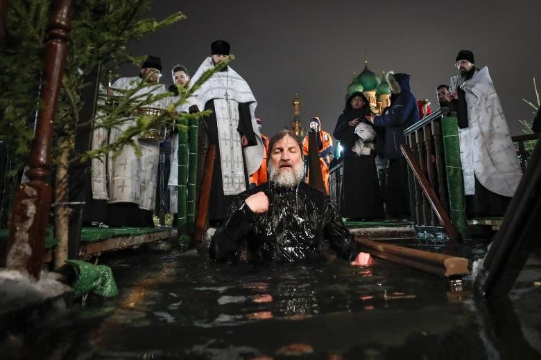 Moscow (Russian Federation), 18/01/2023.- Russian Orthodox priest takes a dip in the ice cold water of a pond during the celebrations of the Orthodox Epiphany holiday, in Moscow, Russia, 18 January 2023. People believe that dipping into blessed waters during the holiday of Epiphany strengthens their spirit and body. (Rusia, Moscú) EFE/EPA/YURI KOCHETKOV