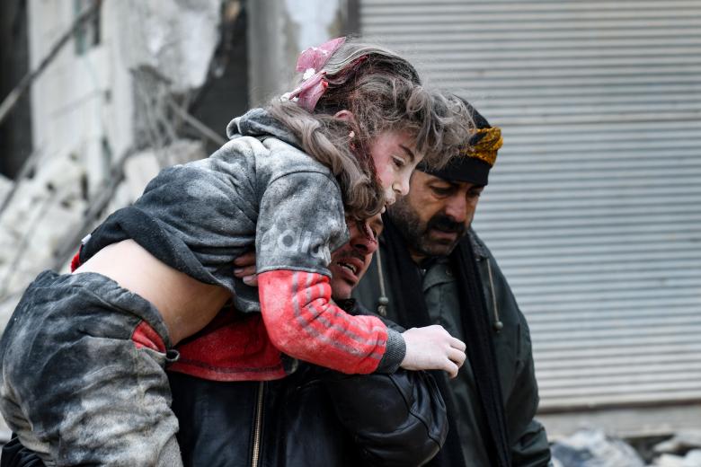 Un hombre saca de entre los escombros a una niña siria