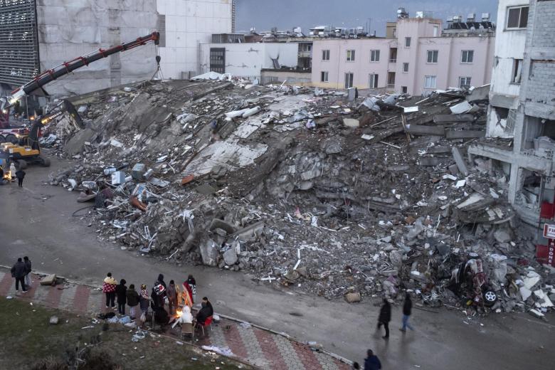 Las grúas trabajan entre los escombros de un edificio destruido en Hatay (Turquía)