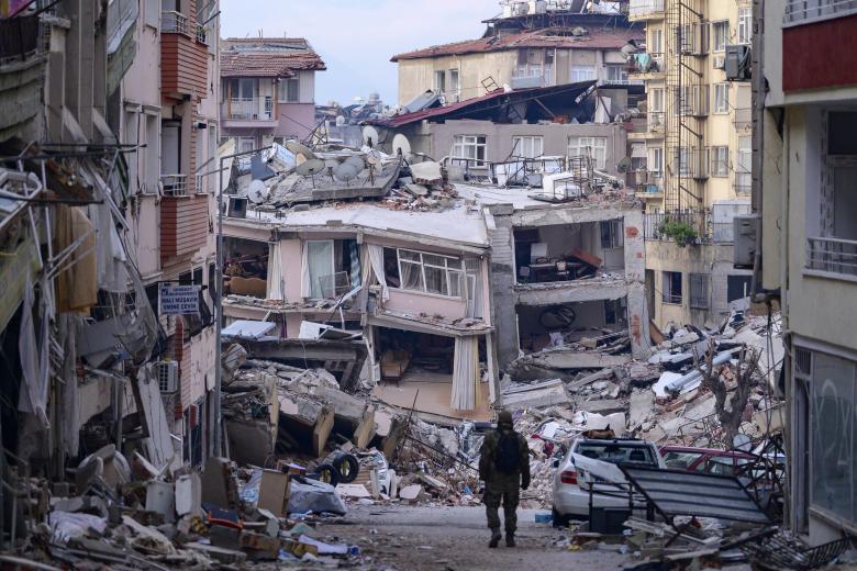 Un soldado turco camina entre edificios destruidos en Hatay
