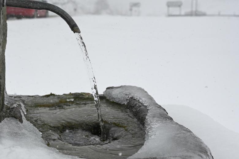 El agua corre en una fuente casi congelada, este jueves en Villamanín, León.