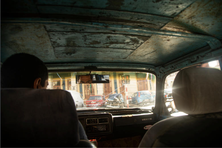 Un taxista con su viejo vehículo destartalado en La Habana