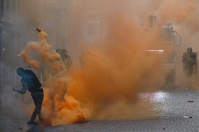 n manifestante lanza un bote de humo naranja hacia la policía antidisturbios francesa (CRS) durante una manifestación organizada por pescadores contra las regulaciones y la persecución de la Dirección de Asuntos Marítimos (direction des affaires Maritimes), en Rennes, en el oeste de Francia.