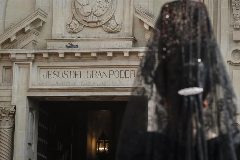 SEVILLA, 06/04/2023.- Una joven ataviada con una mantilla espera en el exterior de la Basílica de Jesús del Gran Poder, cuya imagen saldrá en procesión en la Madrugá sevillana, este Jueves Santo en Sevilla. EFE/Jose Manuel Vidal