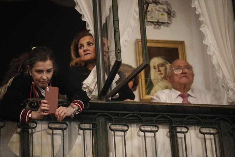 AME9632. SEVILLA (ESPAÑA), 06/04/2023.- Vecinos observan hoy la procesión de la Virgen de la Esperanza de Triana, a la salida de la capilla de los Marineros, durante la celebración de la Madrugá sevillana, una noche con seis cofradías recorriendo el centro de Sevilla (España). EFE/José Manuel Vidal